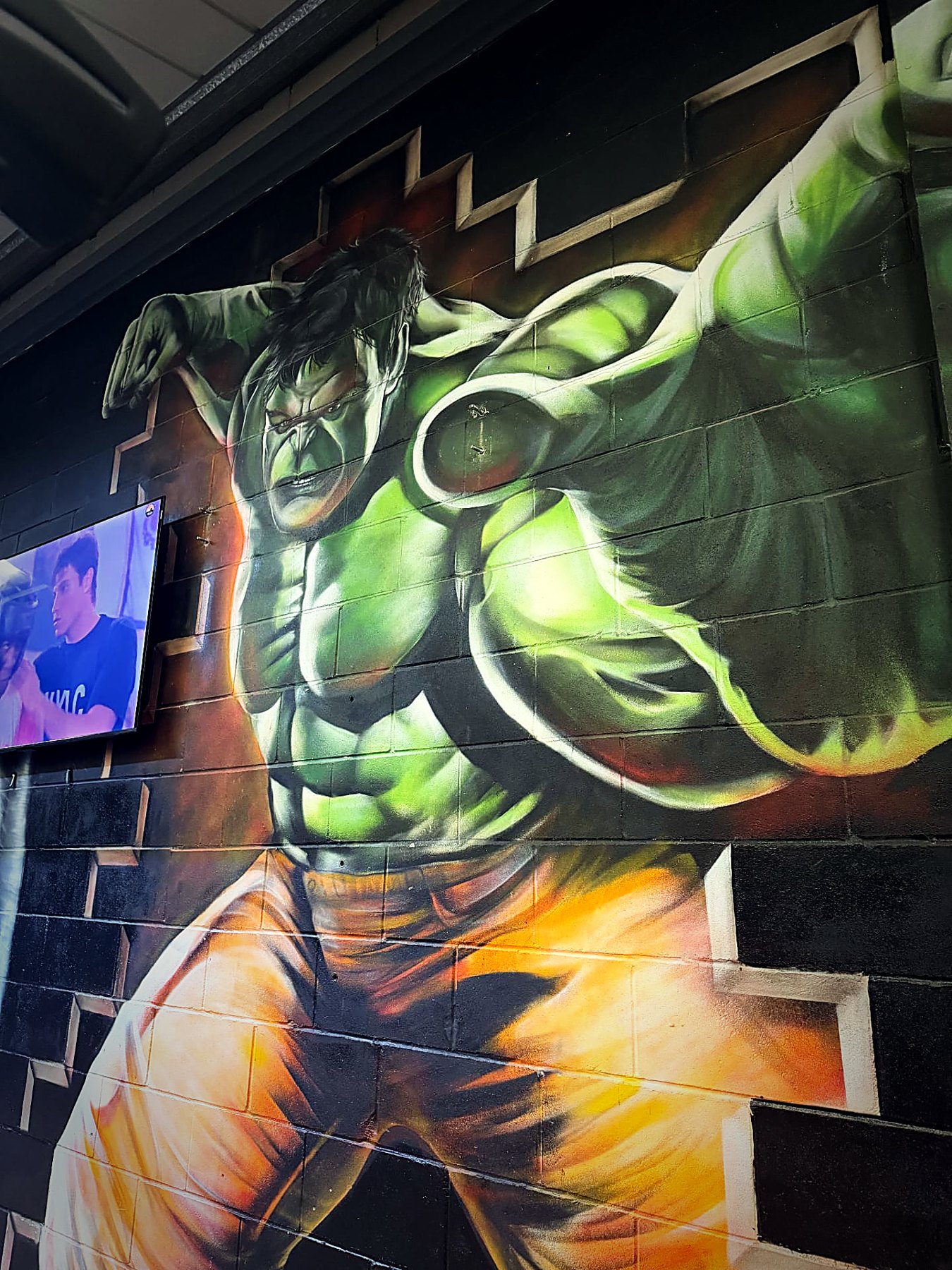 Giant green hulk-style mural painted on the gym wall
